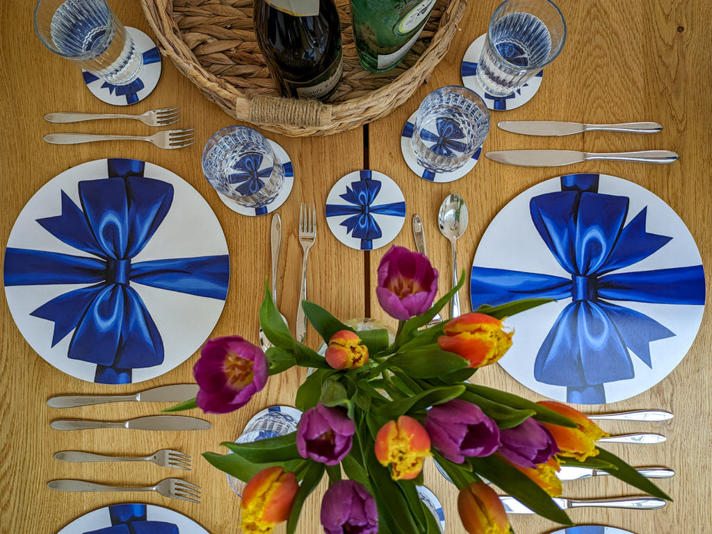 Birdseye view of party tablesetting with blue ribbon placemats and coasters
