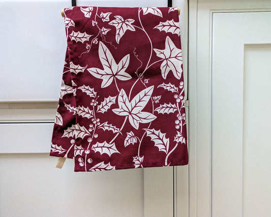 Holly and Ivy burgundy and white Christmas tea towel hanging in a fresh white kitchen