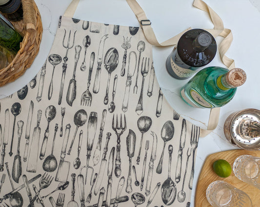 Cutlery illustrated apron laid on a marble surface with drinks preparation
