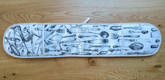 Overview of cutlery oven gloves showing the full design on a warm oak tabletop