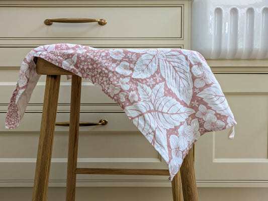 Floral-patterned towel draped over a wooden stool with a neutral kitchen background