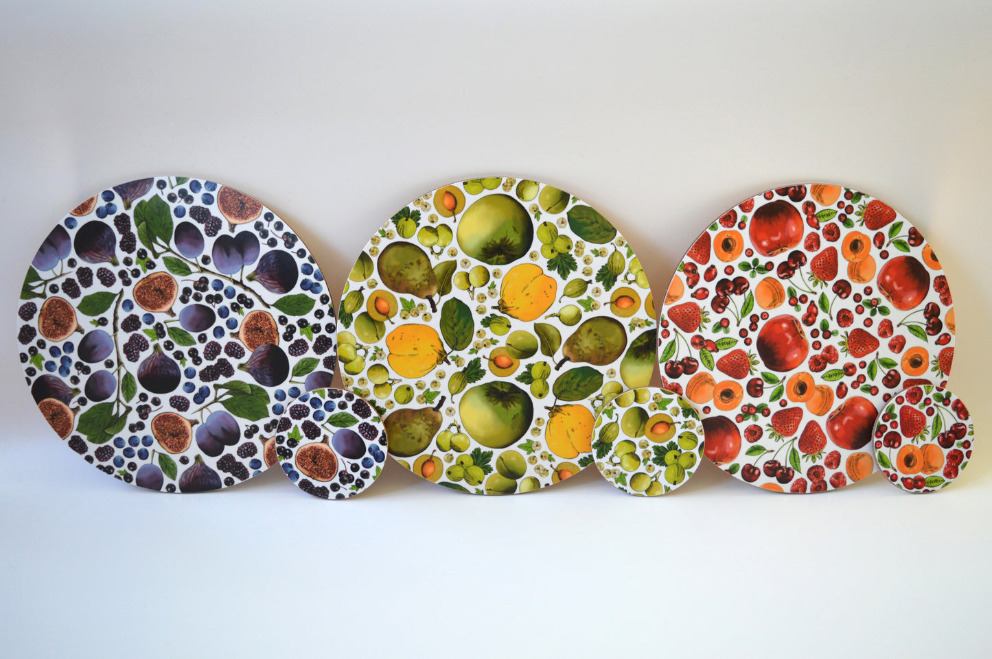 Fruit placemats and coasters lined up - colourful hardwearing tableware