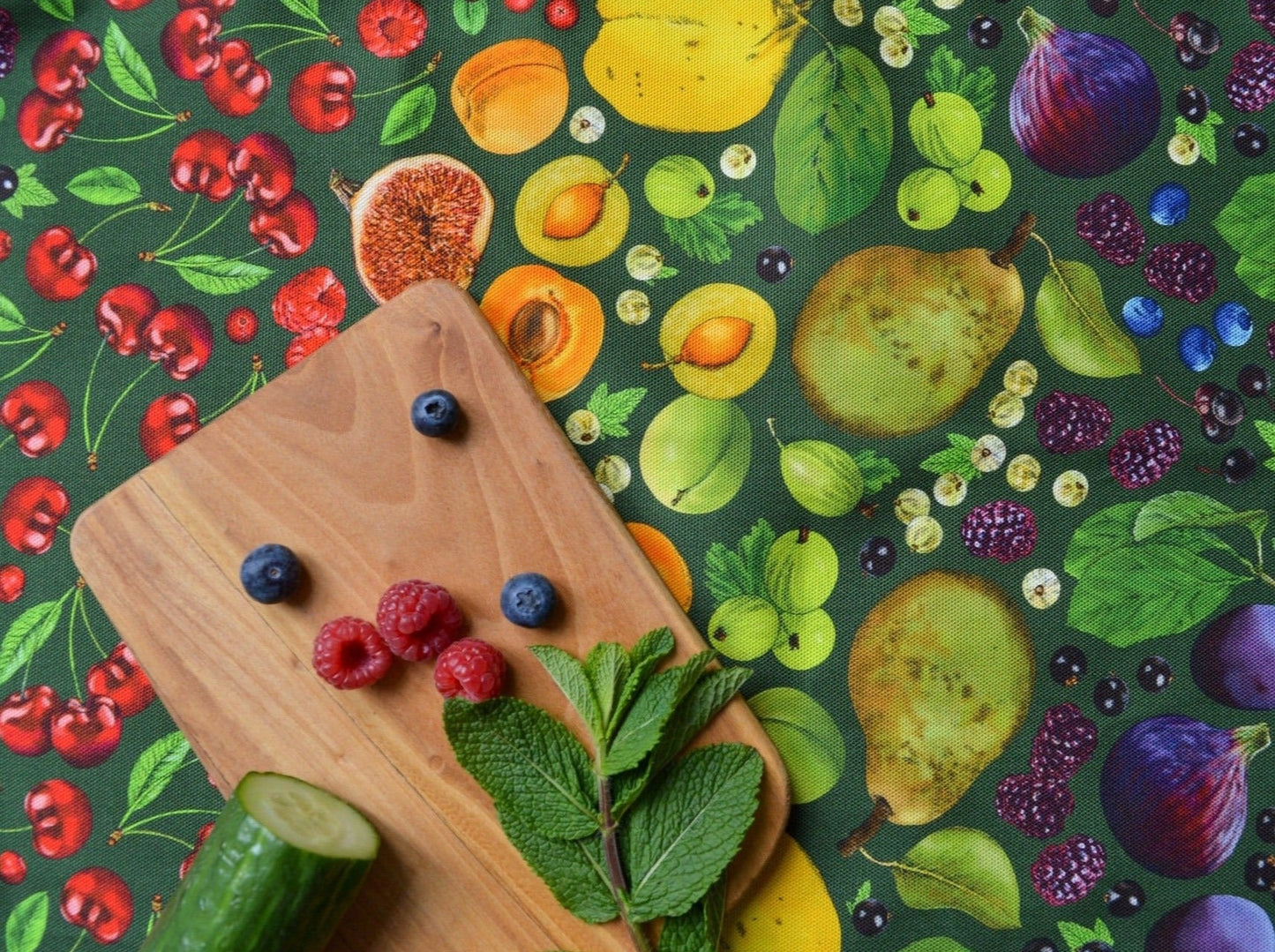 Close up of green colourway fruit illustrated cotton tea towel