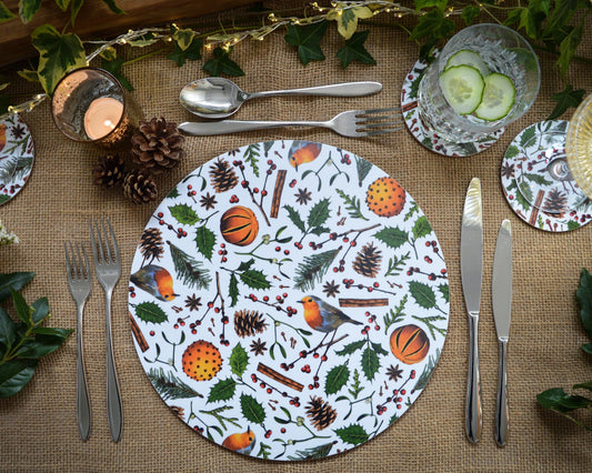 Christmas table setting, Christmas placemat with robins, holly, fir cones, berries, spiced oranges and cinnamon