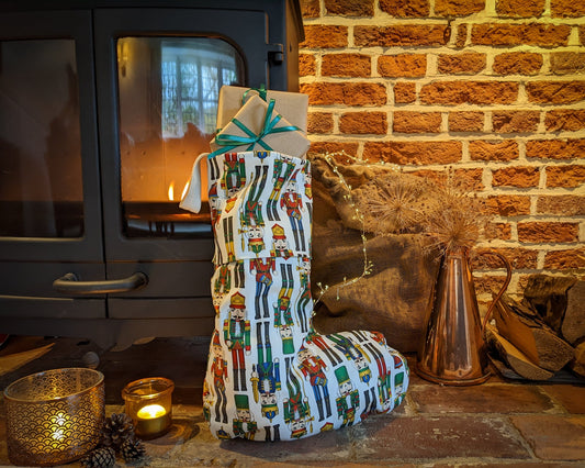 Nutcracker colourful stocking propped up by a lit fire with atmospheric candles and fairy lights
