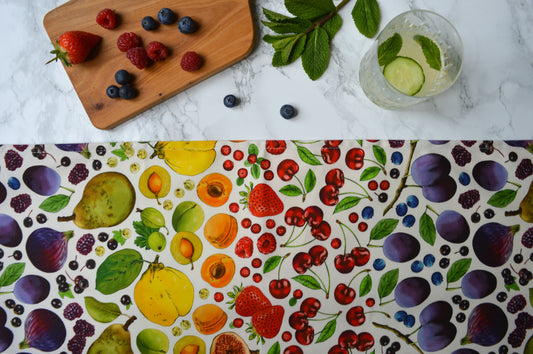 Rainbow fruit tea towel, natural background on marble top with fresh fruit and drinks