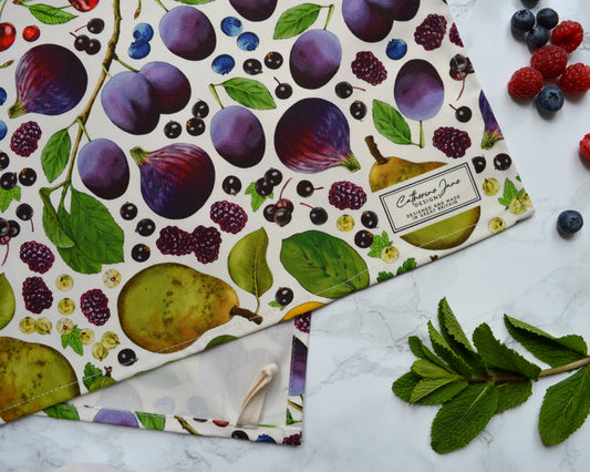 Close up of detailed illustrated rainbow coloured fruit tea towel. Nature inspired kitchenware