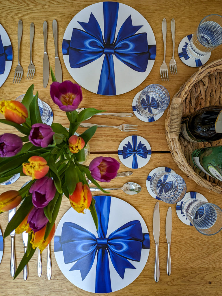 Birdseye view of party tablesetting with blue ribbon placemats and coasters