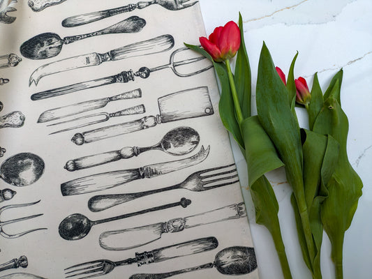 Neutral vintage cutlery illustrated tea towel with fresh cut red tulips