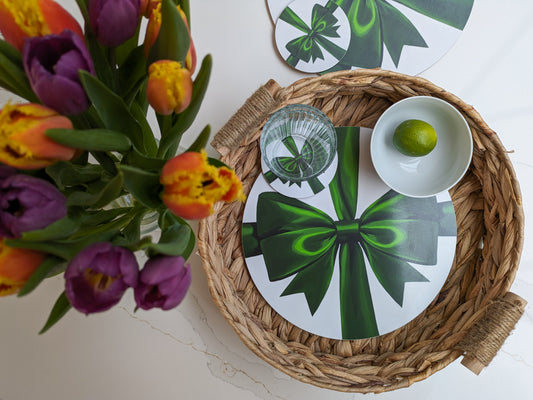 Green ribbon placemat and coasters on a textured tray with fresh flowers