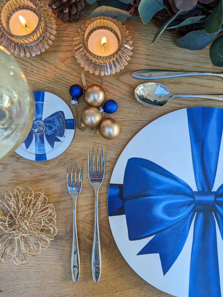 Festive table closeup with blue ribbon placemat and coaster