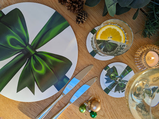 Festive green ribbon placemat and coasters on a laid table