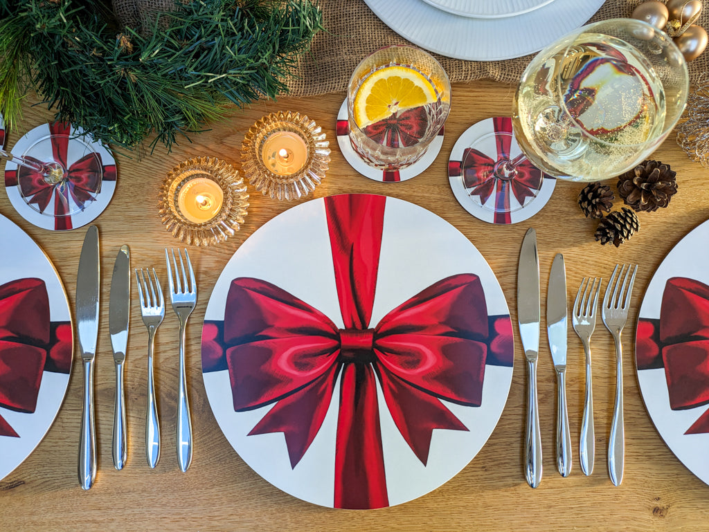 Red ribbon tablesetting with warm lit candles and wine