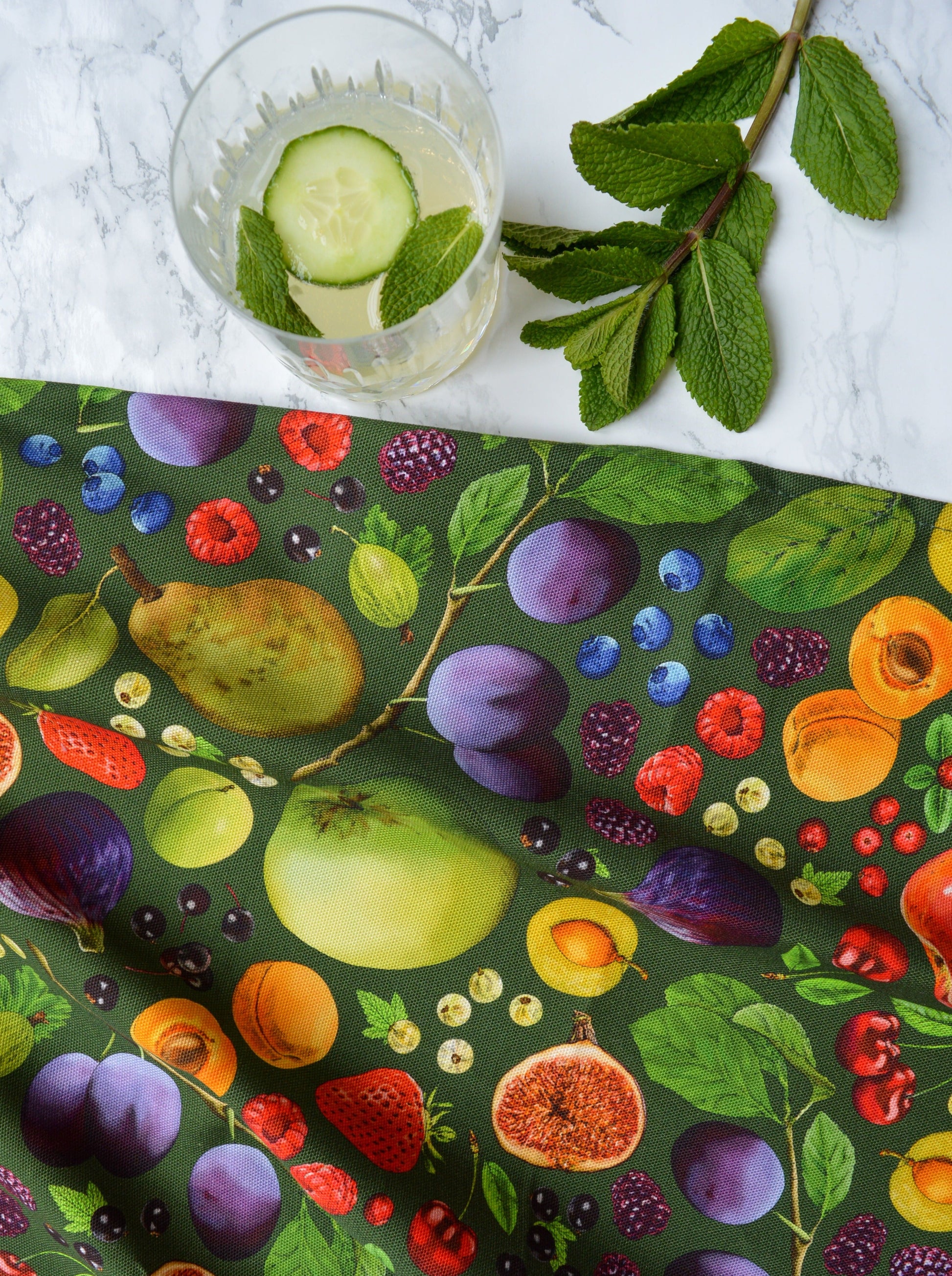 Beautiful fruit illustrated tea towel with fresh produce on a marble top