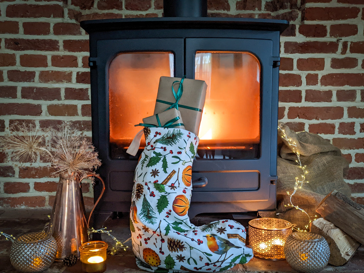 Christmas elements stocking full of gifts. Stocking pattern includes robins, holly, fir cones, berries, mistletoe and spiced oranges on a natural cotton background