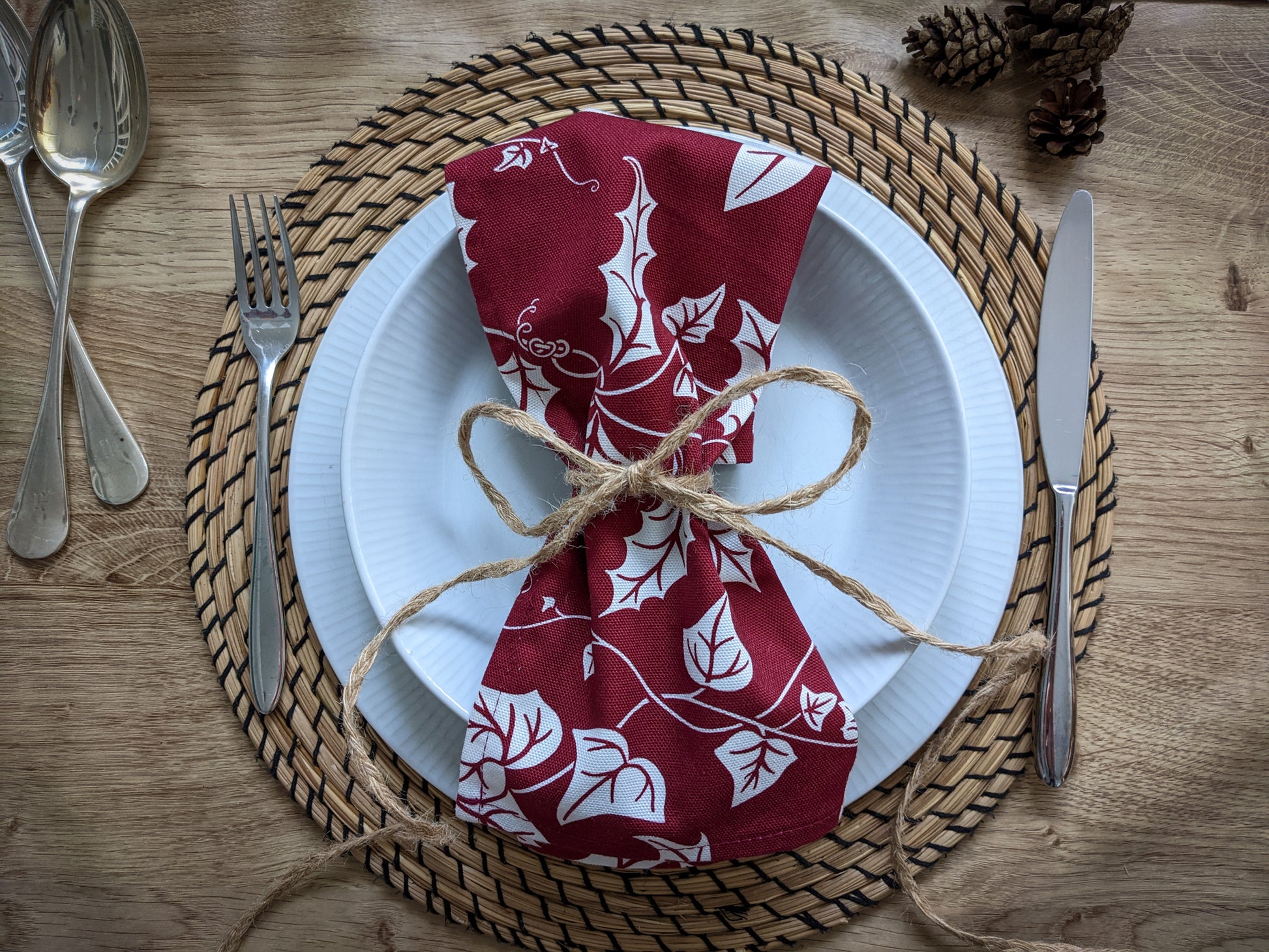 Close up of Holly and Ivy napkin on a wooden table placesetting