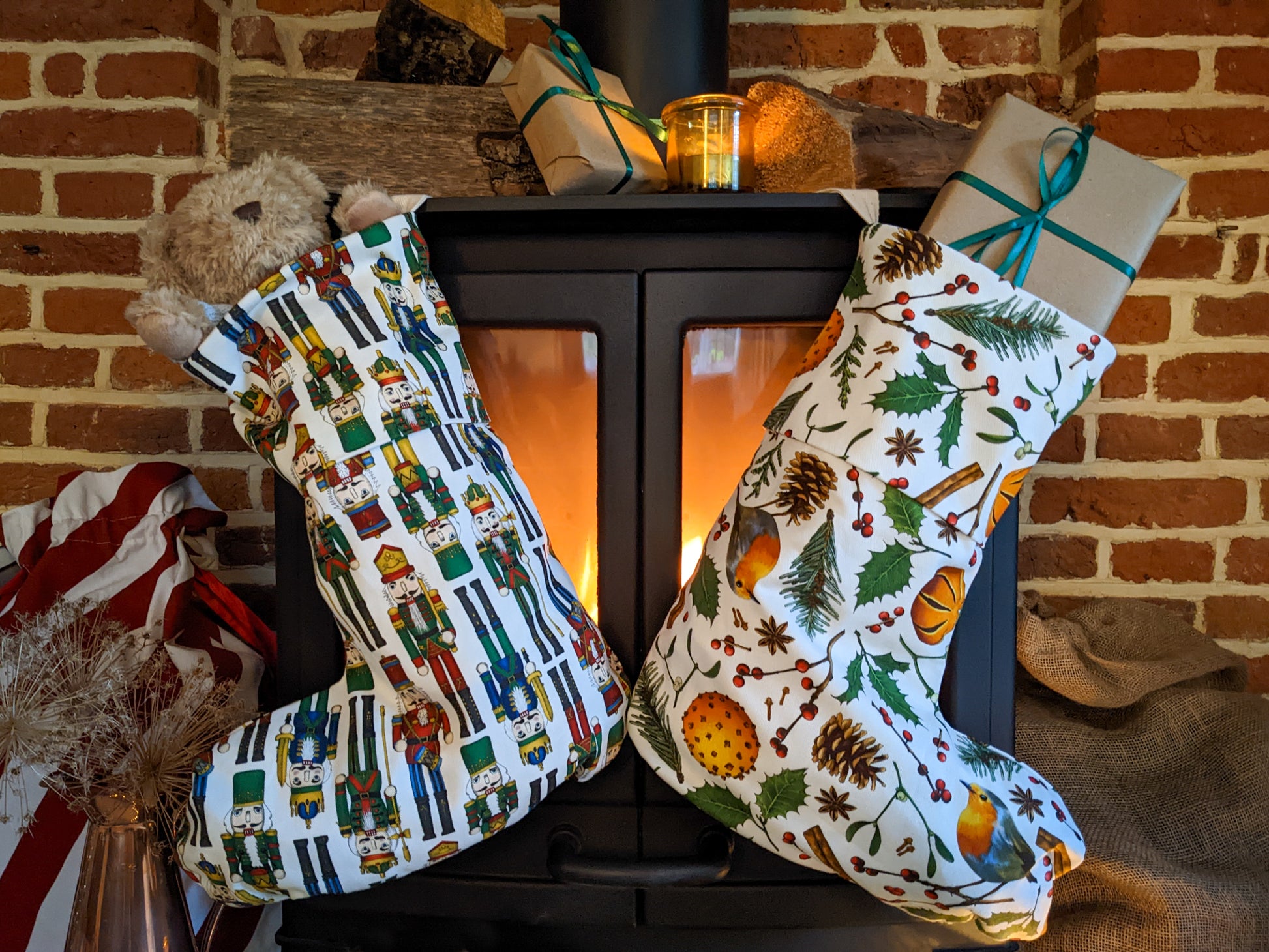 Nutcracker and Elements illustrated organic cotton stockings filled with gifts hanging by a lit fire, cosy Christmas setting